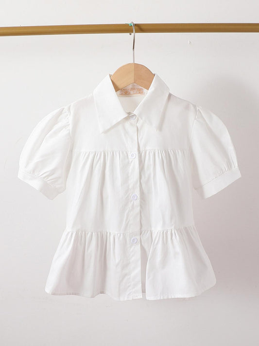 Chemisier blanc à manches courtes pour fille, coupe légère et stylée, idéal pour un look estival chic et décontracté.
