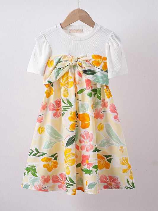 Robe t-shirt blanche pour fille, ornée d’un imprimé de fleurs tropicales colorées, idéale pour un style estival confortable et tendance.