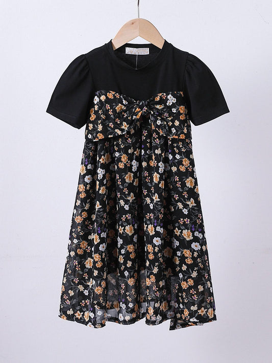 Robe t-shirt noire avec imprimé floral, style décontracté et tendance, idéale pour la saison printemps-été.