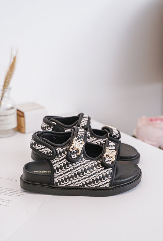 Sandales fille blanches et noires avec boucles dorées. Élégantes, confortables et parfaites pour l’été. 